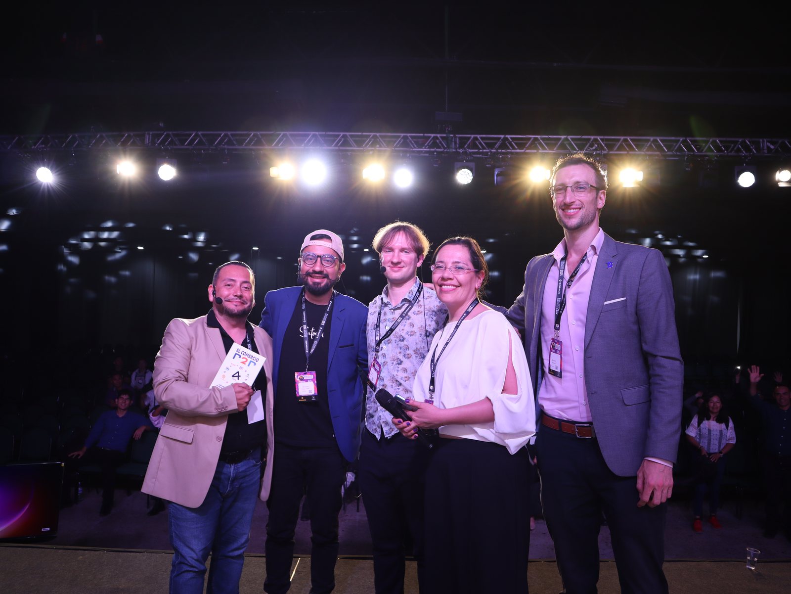 Grupo de speakers en el escenario bajo el logo de Bolivia Blockchain Conference